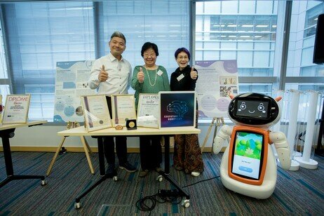 Ms Imma Ling Kit-sum, Treasurer of the Council of EdUHK, takes a group photo with the EduFuture Robotics Co Ltd team, showcasing their AI-powered storytelling robot along with the innovation awards they have received