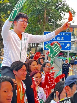 EdUHK cheering team chants and waves props to support the runners