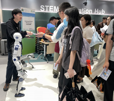 Attendees watch the humanoid robot and quadruped robotic dog showcase their capabilities